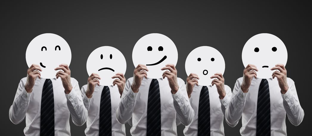 13999500 – businessmens hold plates with smilies on black background alternate text for this image