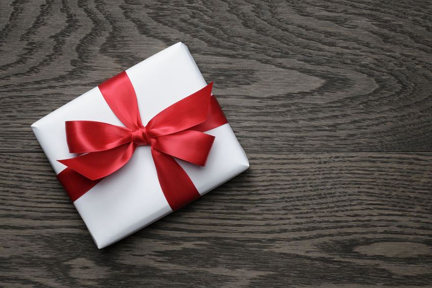 33870666 – gift box with red bow on wood table, top view alternate text for this image