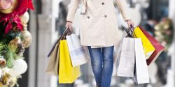 47282061 – woman walking with shopping bags with christmas background. alternate text for this image