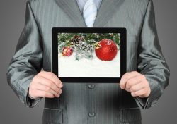 34624335 – man holds tablet pc with christmas composition on dark background alternate text for this image
