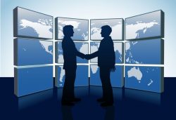 9712937 – business people shake hands agreement and world map monitors alternate text for this image