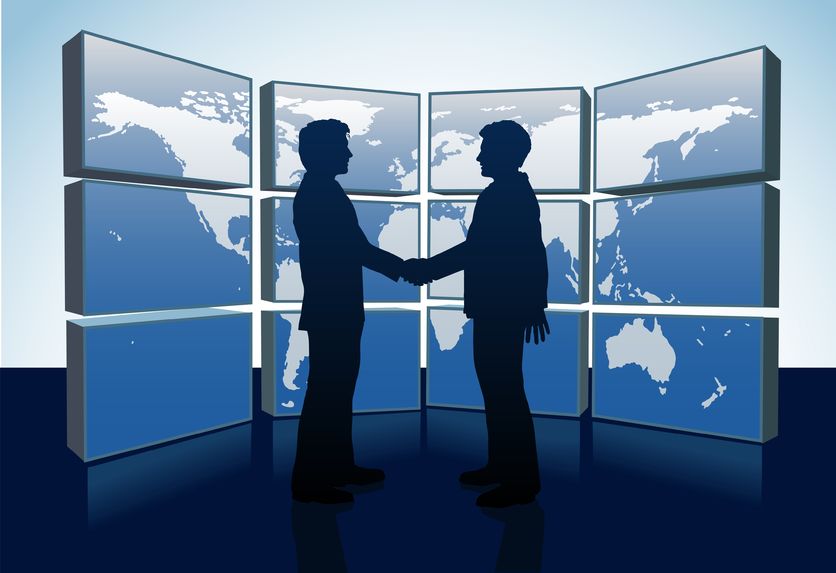 9712937 – business people shake hands agreement and world map monitors alternate text for this image