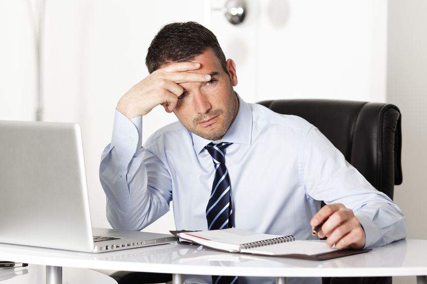9611248 – pensive man in office with computer and pen alternate text for this image
