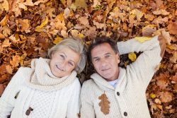 46449912 – active seniors lying on the ground in colorful autumn leaves. alternate text for this image