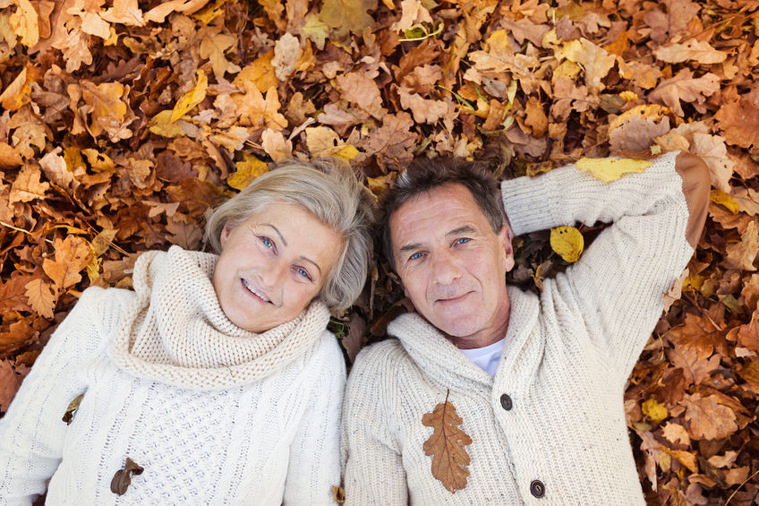 46449912 – active seniors lying on the ground in colorful autumn leaves. alternate text for this image