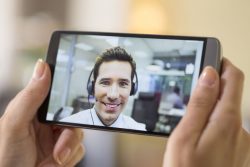 33665611 – closeup of a female hand holding a smart phone during a skype video alternate text for this image
