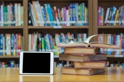 43952657 – old book on the desk in library with tablet and glasses alternate text for this image