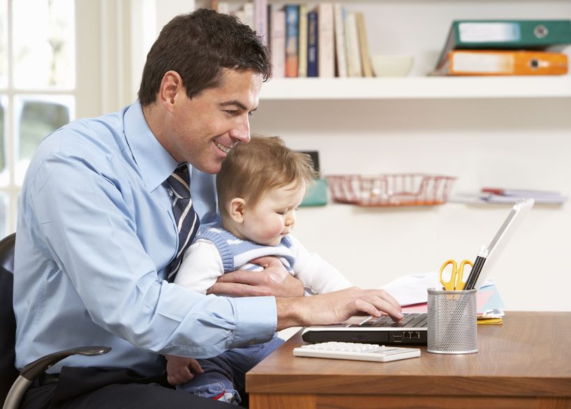 9911425 – man with baby working from home using laptop alternate text for this image