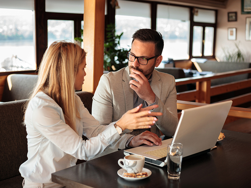 Two young male and female business partners having a meeting in a cafe alternate text for this image