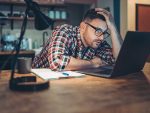 Man looking at a laptop in concern or frustration