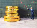 Miniature model man looking giant stack of chocolate coins