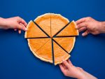 Sliced pumpkin pie above view on blue background. People grabbing slices of cake stock photo