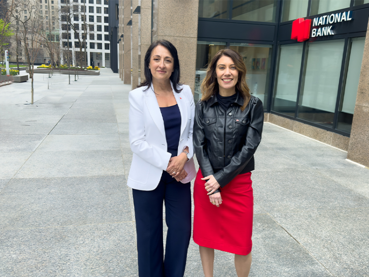 2 professional women from National Bank standing outside next to each other outside the National Bank office.