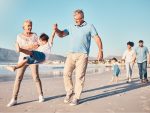 Grandparents walking with grandchild on the beach