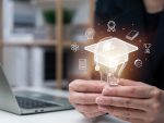 Businessperson holding lightbulb with learning concept around it