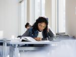Focused young woman doing homework