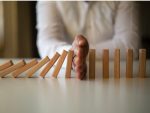 Businessman Stop Domino Effect. Risk Management and Insurance Concept