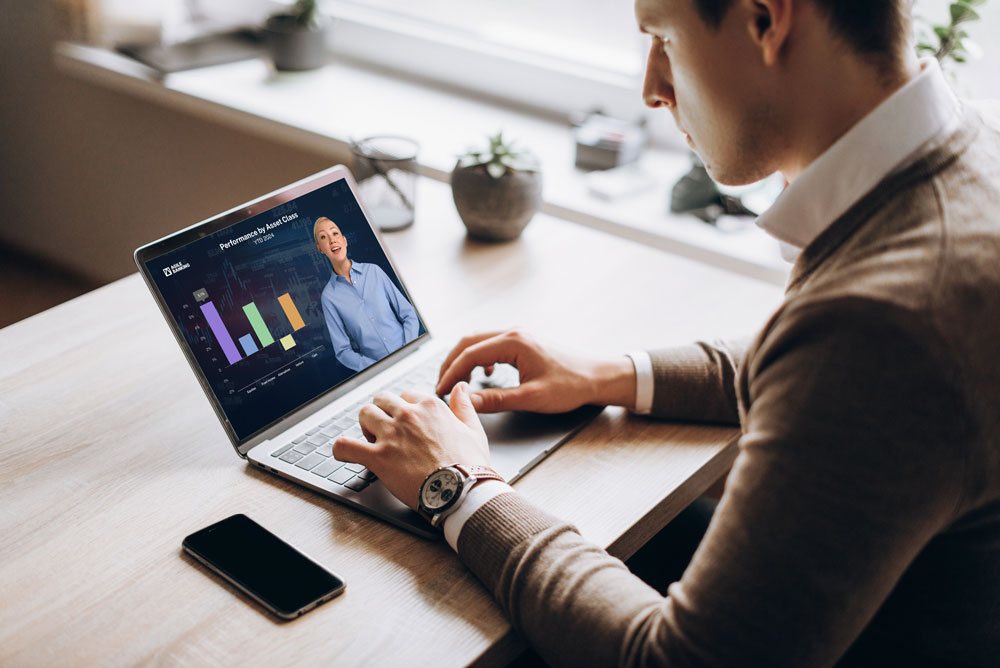 A man watching a video on his laptop with a bar chart.